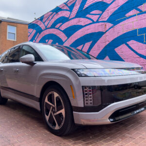 A Hyundai Ioniq 9 parked next to a mural in an alley