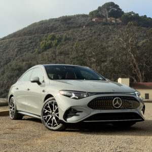 A Mercedes-Benz CLA parked by a green hill