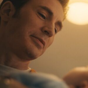 handsome blond man looking down a newborn baby with love