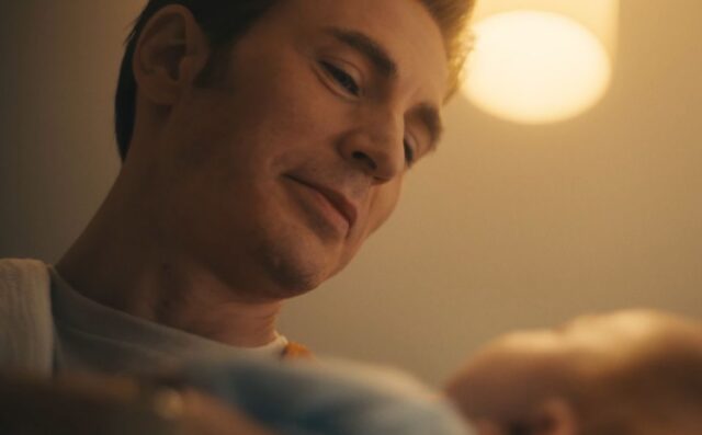 handsome blond man looking down a newborn baby with love
