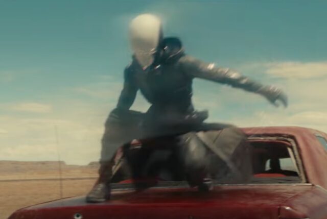 Figure dressed in black with an all-white helmet on the hood of a car