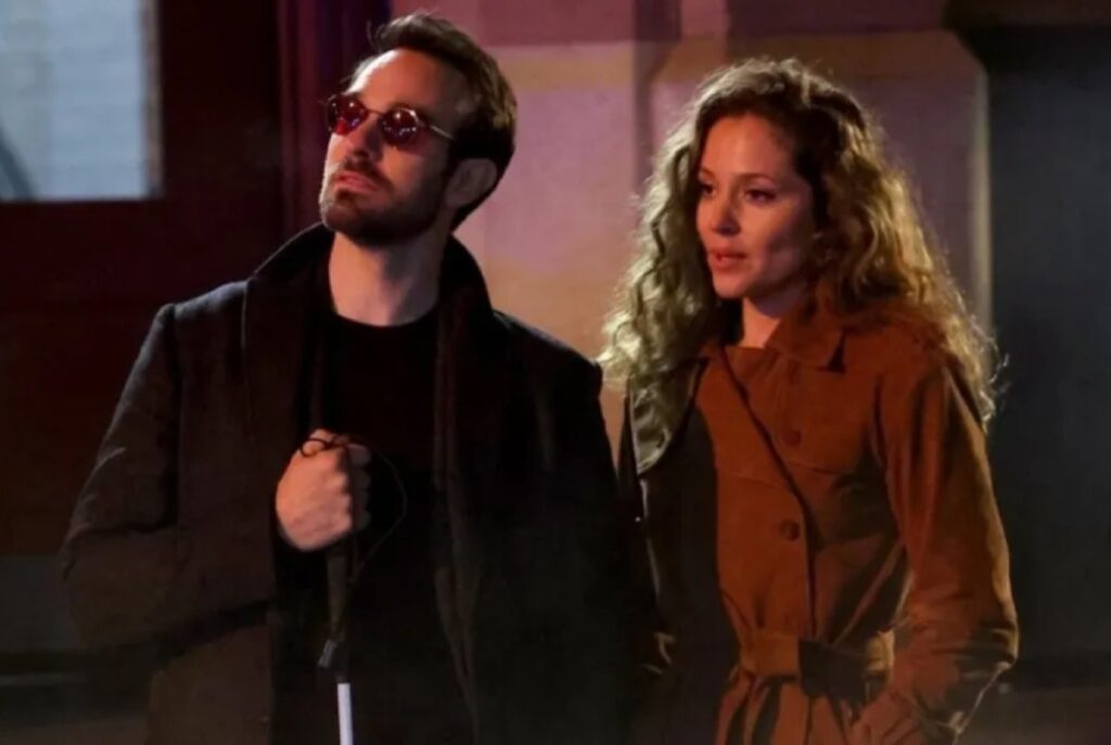 blind man arm in arm with a lovely brunette woman i a red coat