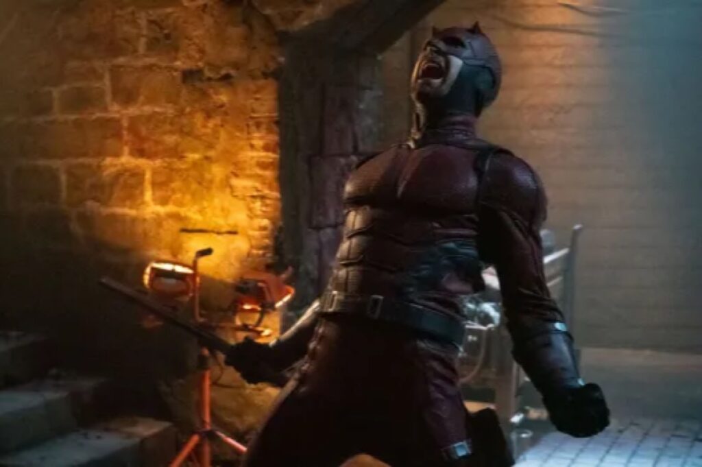 Man in dark red Daredevil costume leaning backward and screaming in rage/anguish,
