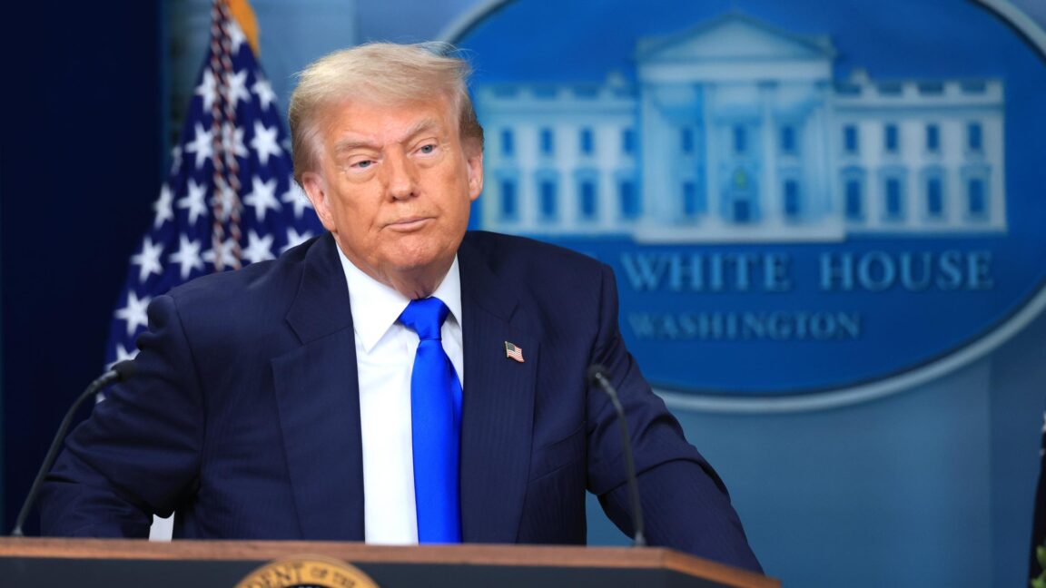 President Trump stands behind a podium while answering questions during a press conference at the White House.