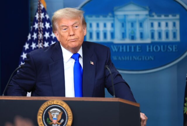 President Trump stands behind a podium while answering questions during a press conference at the White House.