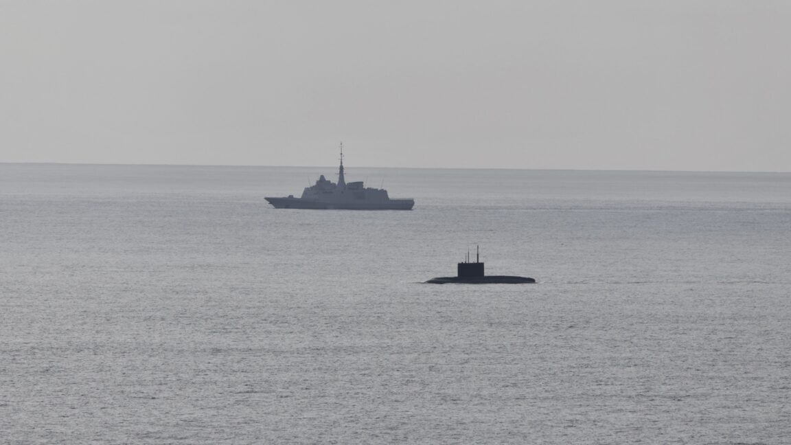 A French Navy vessel watches the surfaced Russian sub Novorossiysk this week.
