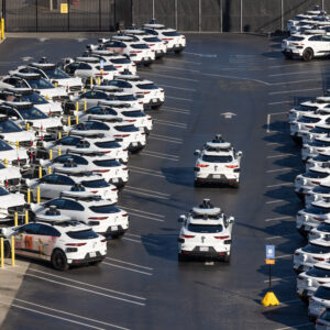 white waymo cars in parking lot