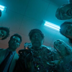 group of scruffy looking people bending over to look directly into the camera