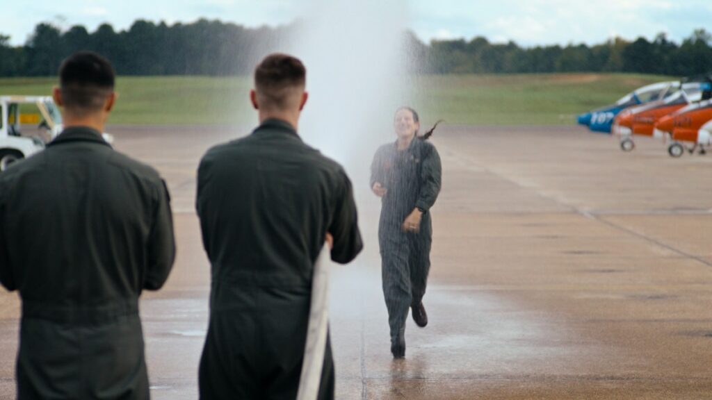 An elated student is doused by her classmates to celebrate the completion of her training.