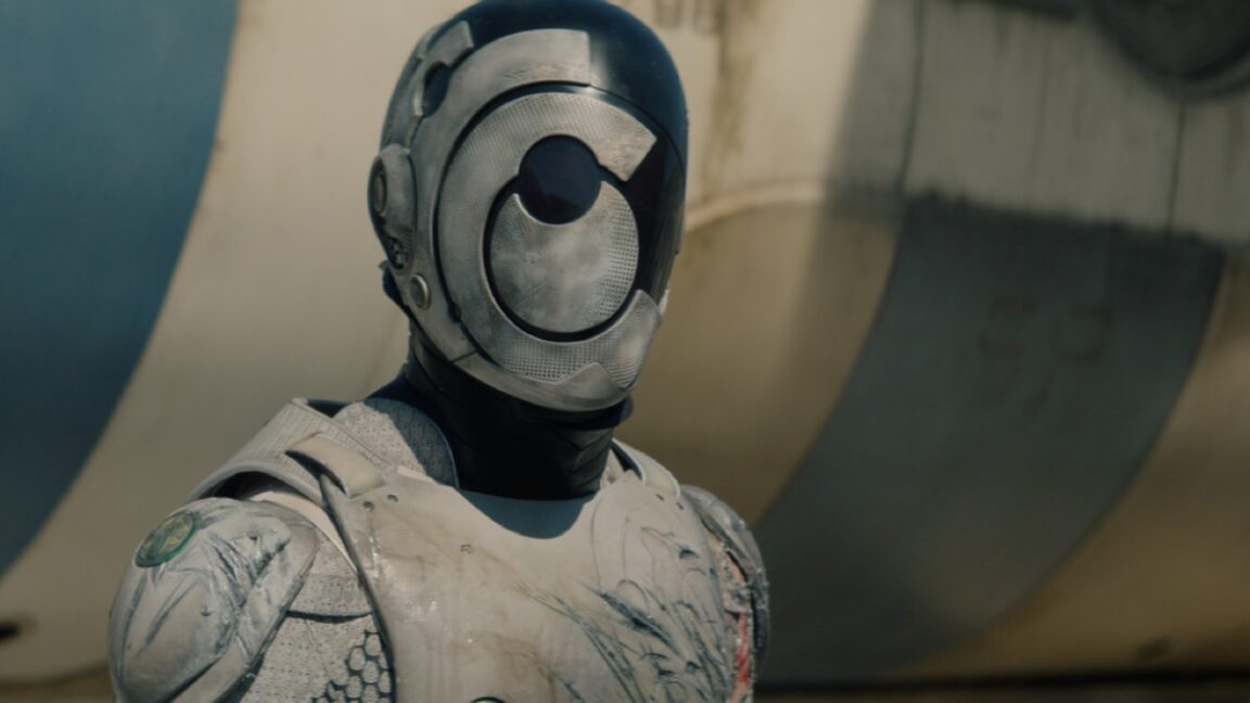 shot of head and upper torso of white armored robot and a faceless mask