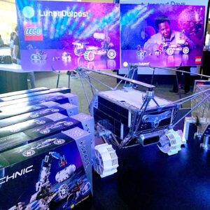 toy boxes and mockup moon rovers sit side by side on a display table