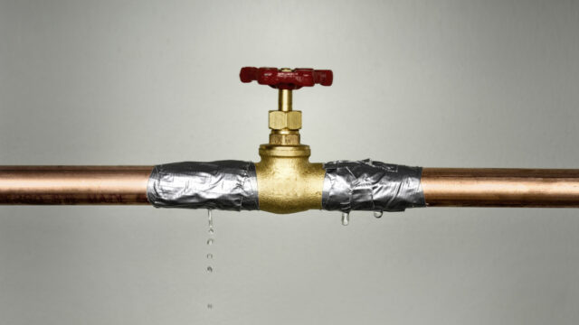 Closeup shot of the leaking water pipe with red valve