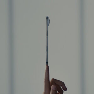 An iPhone appears to balance on a fingertip