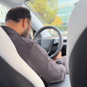 A screenshot of a video showing a man asleep at the wheel of a car.